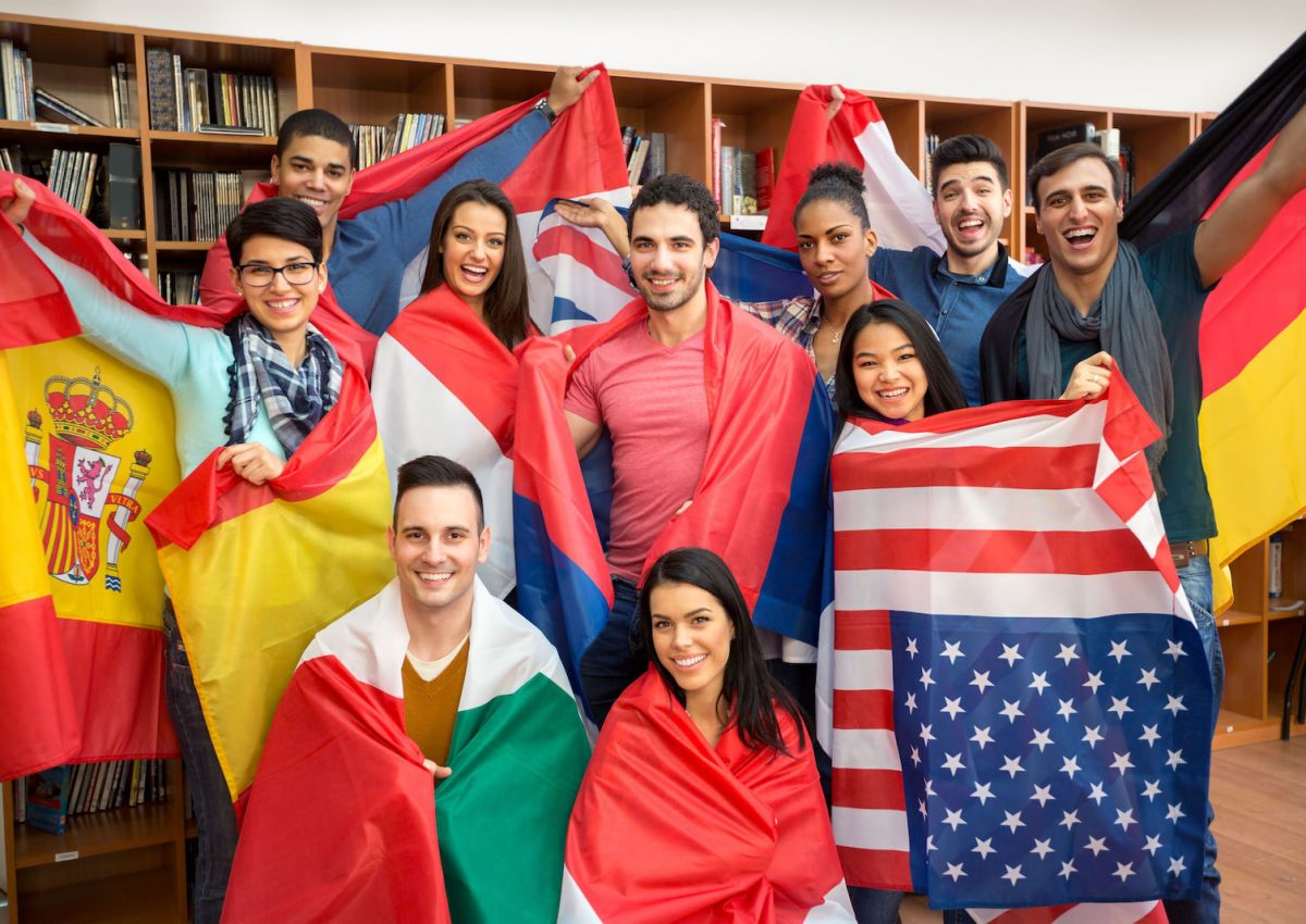 International multiethnic exchange of students, happy students presenting their countries with flags